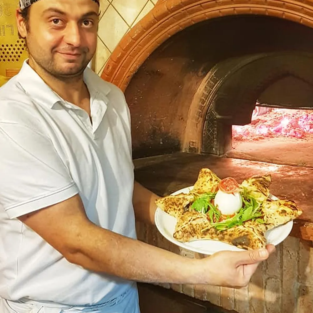 Alfonso con una pizza appena sfornata